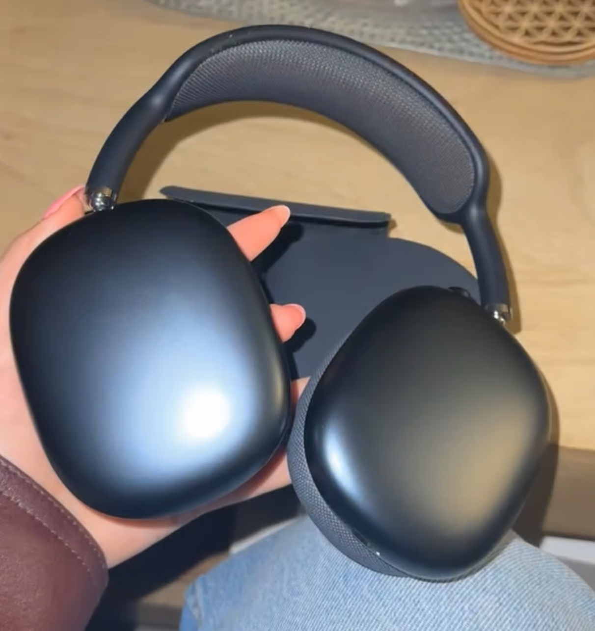 Customer holding black Hidden Maxes headphones